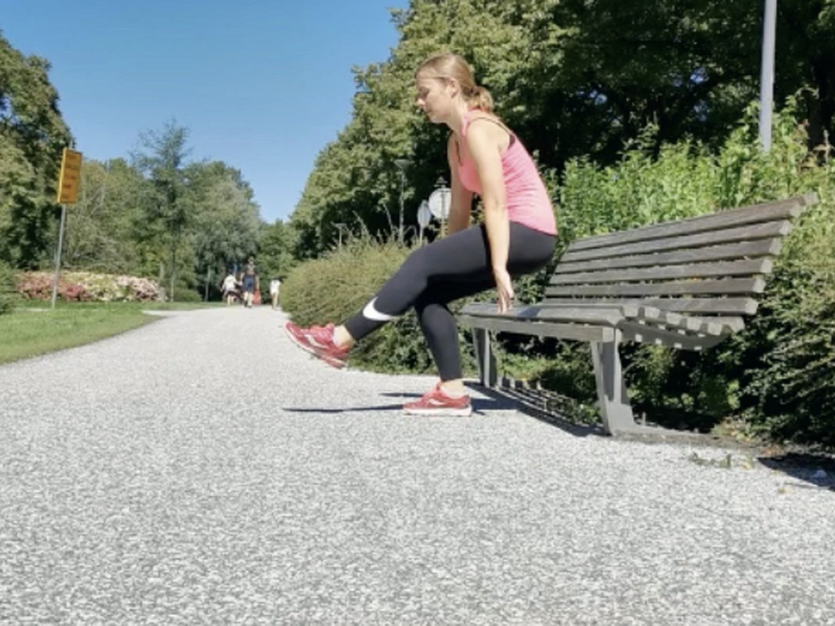 Iemand die op een bankje in een park een oefening doet