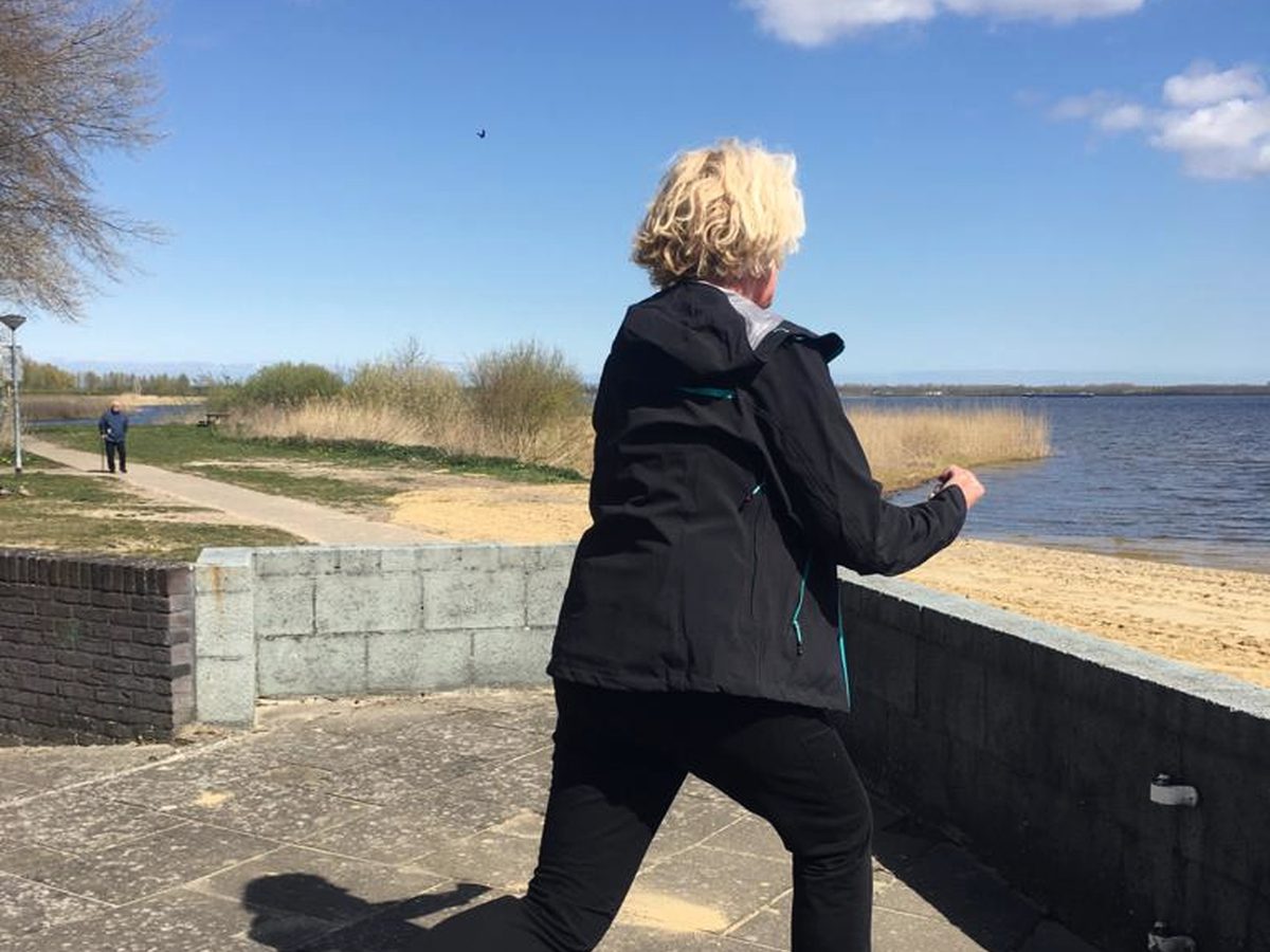 Iemand met een jas aan die buiten aan het water traint