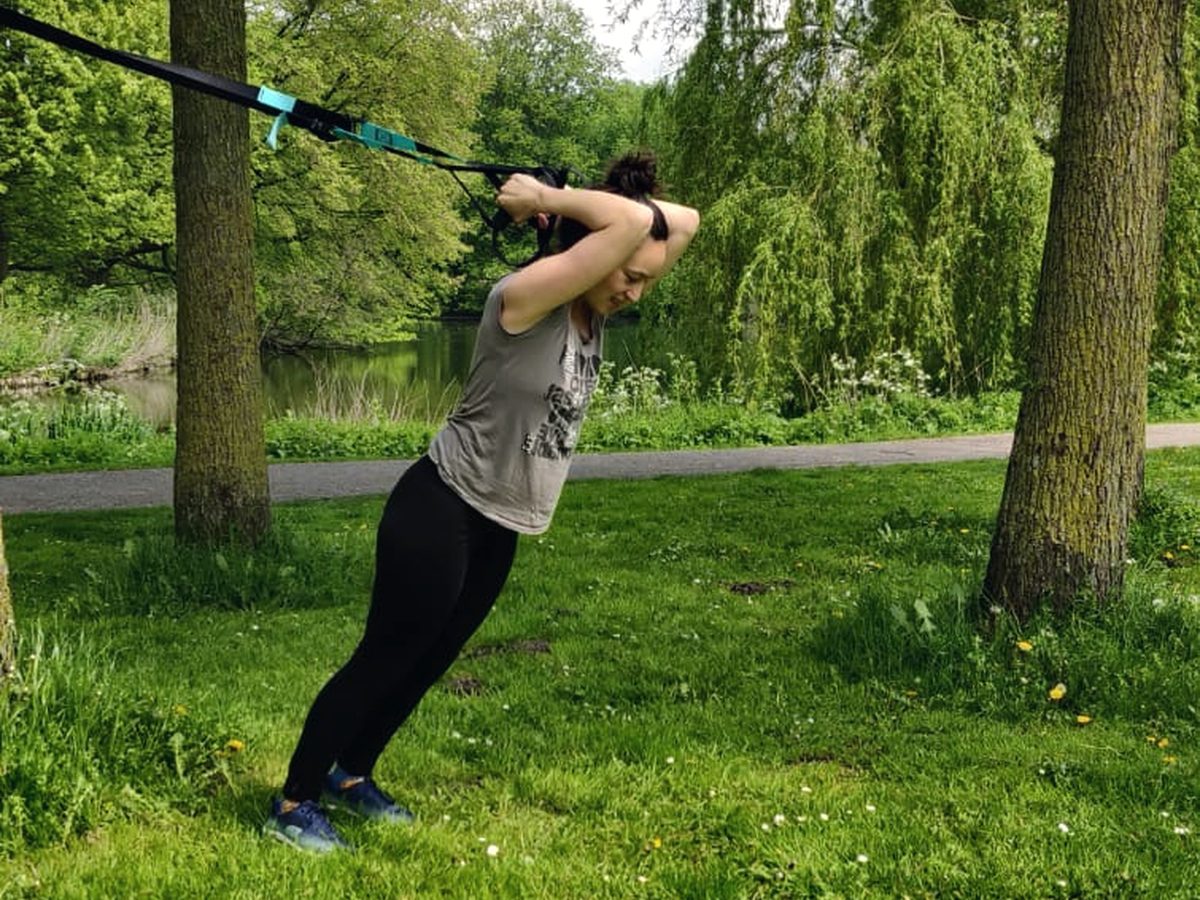 Iemand die buiten met een trainingssysteem aan een boom traint